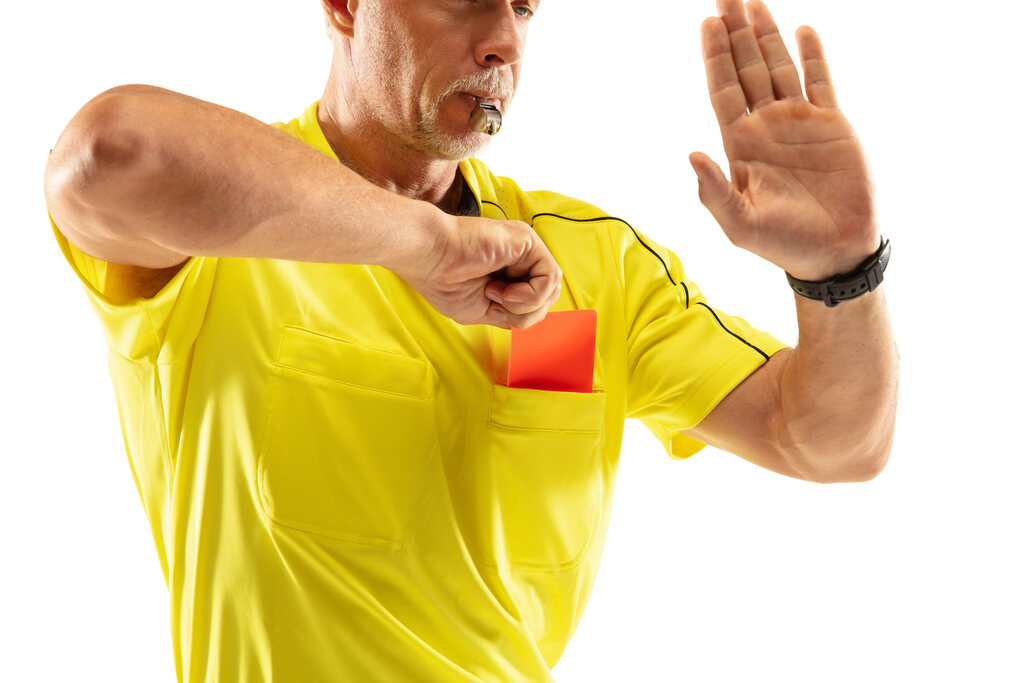 Arbitro de futebol retirando o cartão vermelho do bolso