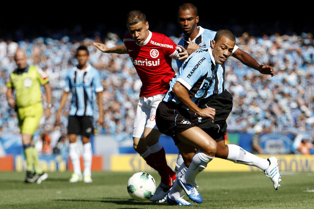 Jogadores do Internacional e do Grêmio em disputa de bola durante o clássico "Grenal".