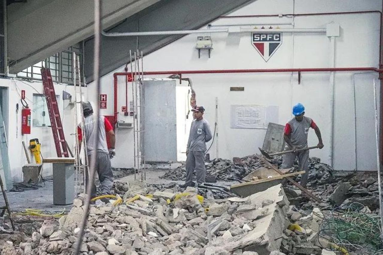 Homens trabalhando em meio aos escombros da obra no CT da Barra Funda do São Paulo.