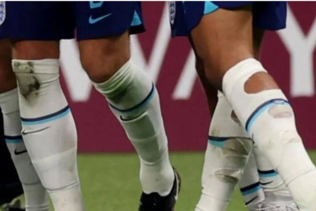 Imagens das pernas de jogadores com um corte circular na parte traseira do meião