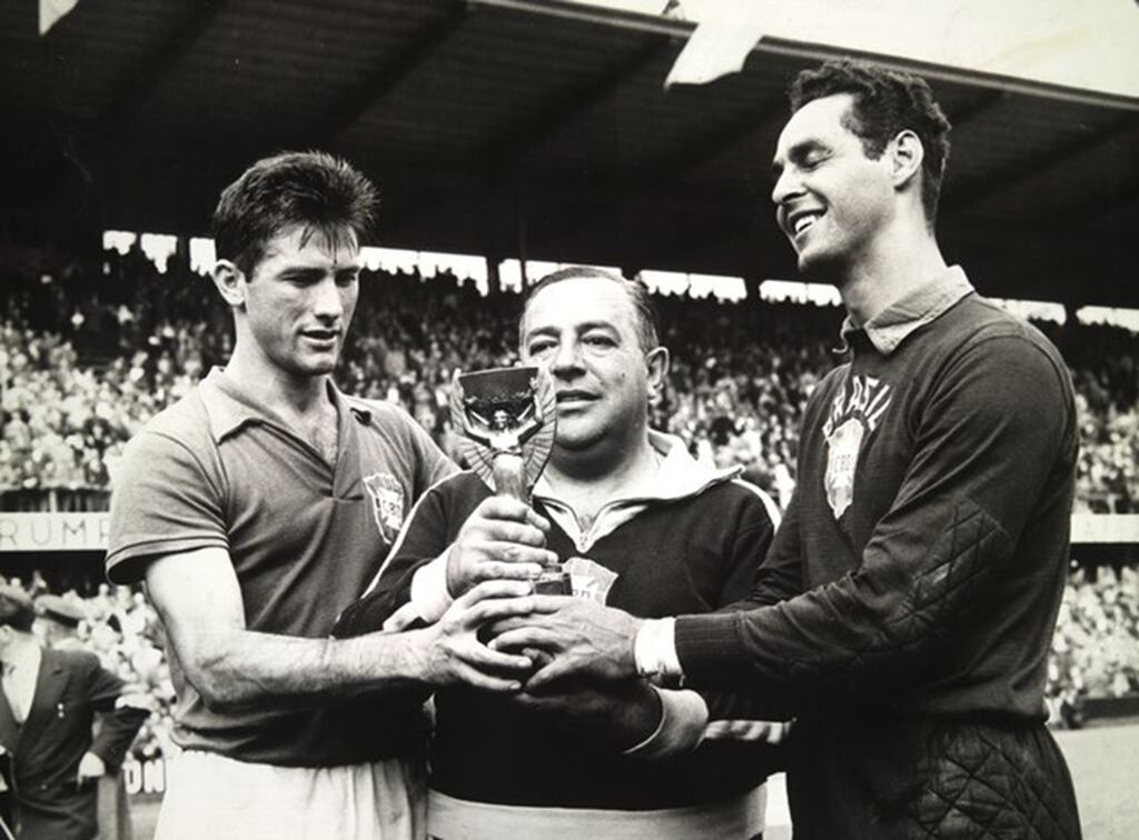 Bellini, Vicente Feola e Gylmar seguram a taça da Copa do Mundo de 1958, em preto e branco.