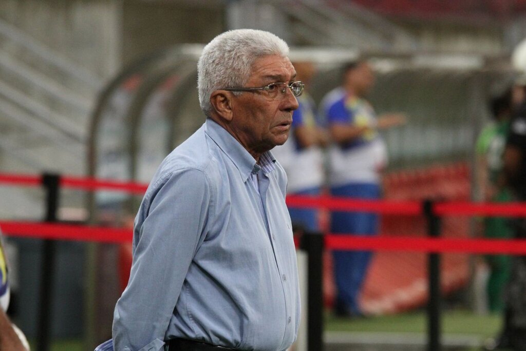 Técnico de futebol Givanildo, vestindo camisa social azul, com as mãos para trás, durante trabalho no Santa Cruz.