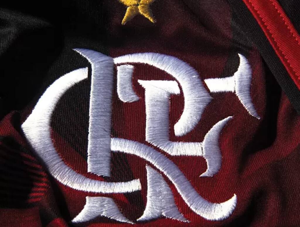 Escudo do Flamengo bordado em sua camisa vermelha e preta, visto bem de perto.