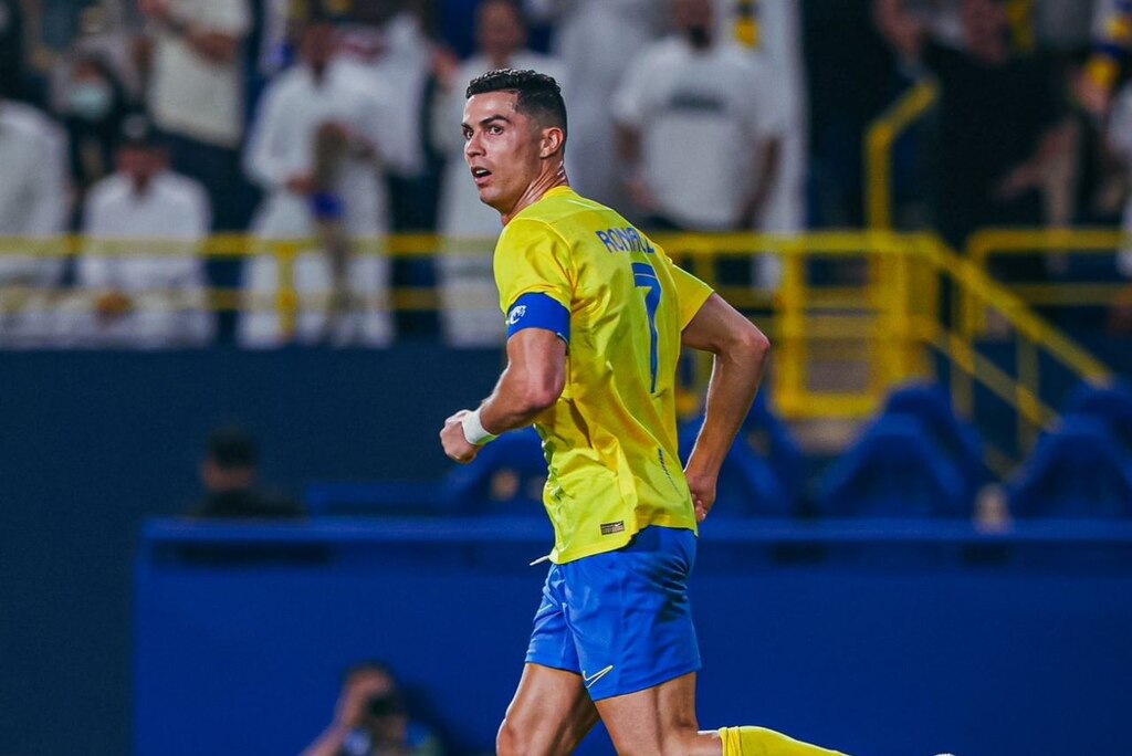 Jogador de futebol Cristiano Ronaldo, usando uniforme amarelo e azul durante partida do Al-Nassr.