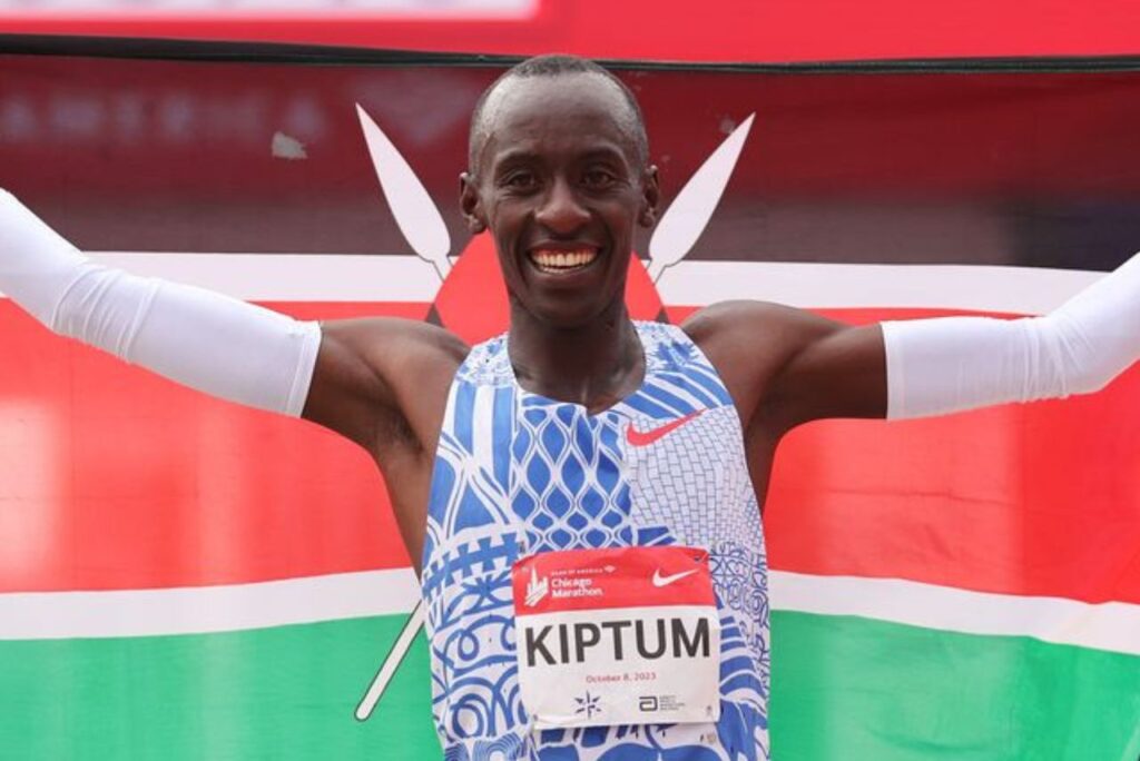 Atleta Kelvin Kiptum comemora com bandeira do Quênia