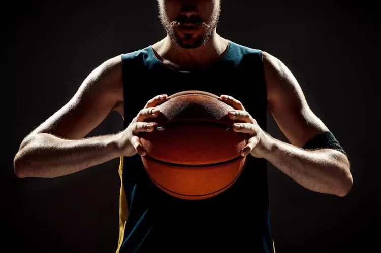 Pessoa segurando uma bola de basquete 