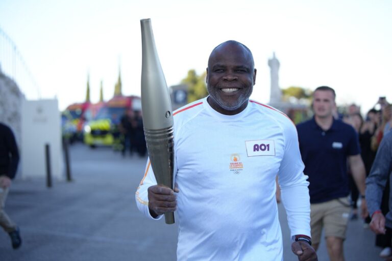 <p>Basile Boli com a tocha olímpica. Foto: Reprodução/Paris-2024</p>
