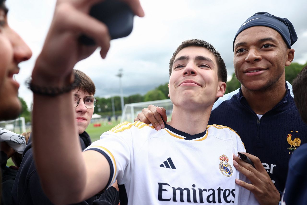 Mbappé ao lado de um torcedor do Real Madrid no treino da França