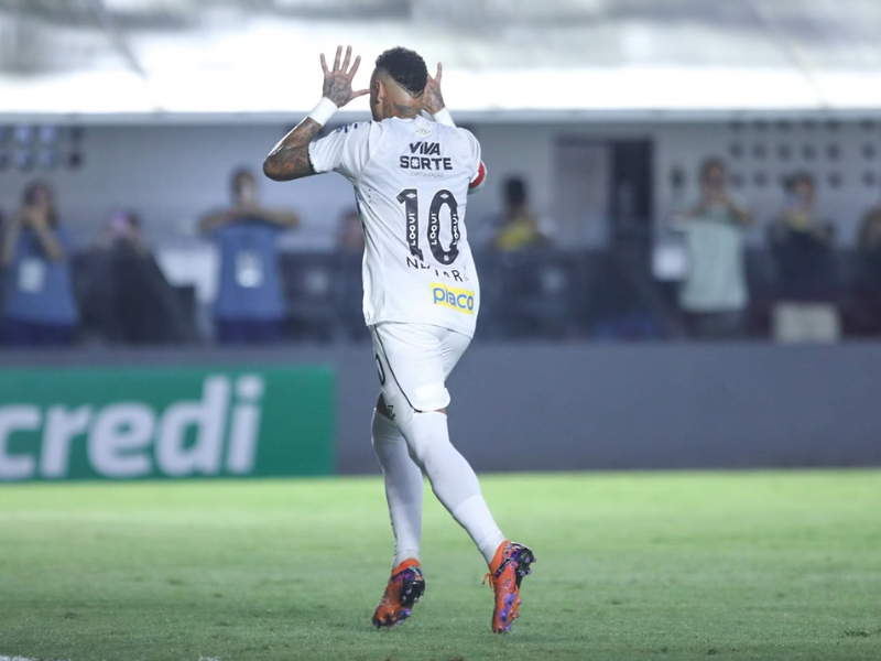 Neymar comemorando gol pelo Santos, com torcida ao fundo.