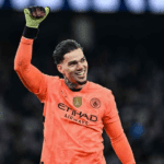 Goleiro Ederson defende a bola em um jogo vibrante da Premier League.