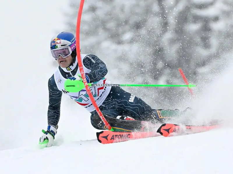 Lucas Pinheiro Braathen esquiando em alta velocidade em uma pista de esqui alpino nevada.