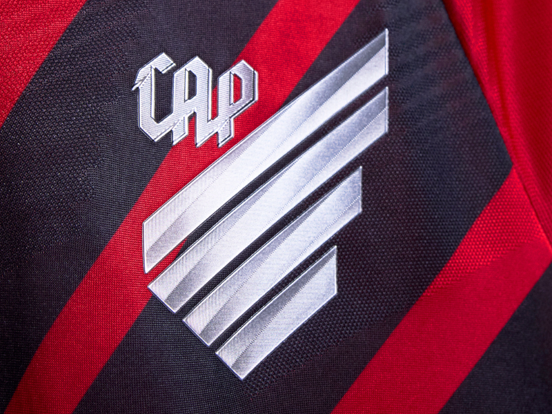 Torcedor do Athletico Paranaense com o rosto pintado e camisa do clube, expressando emoção durante um jogo.