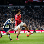 Jogador do Tottenham dribla defensor do Manchester United durante partida acirrada.