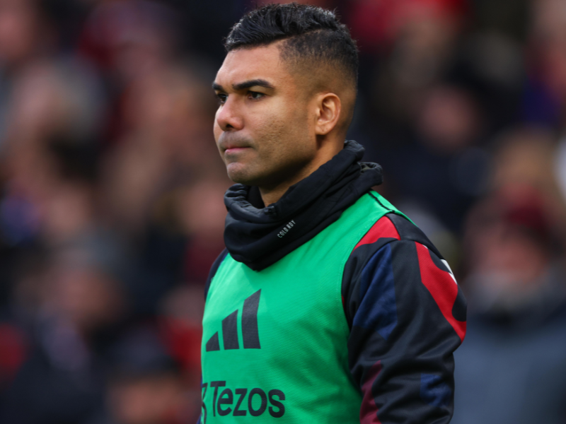 Casemiro sentado no banco de reservas do Manchester United, demonstrando frustração.