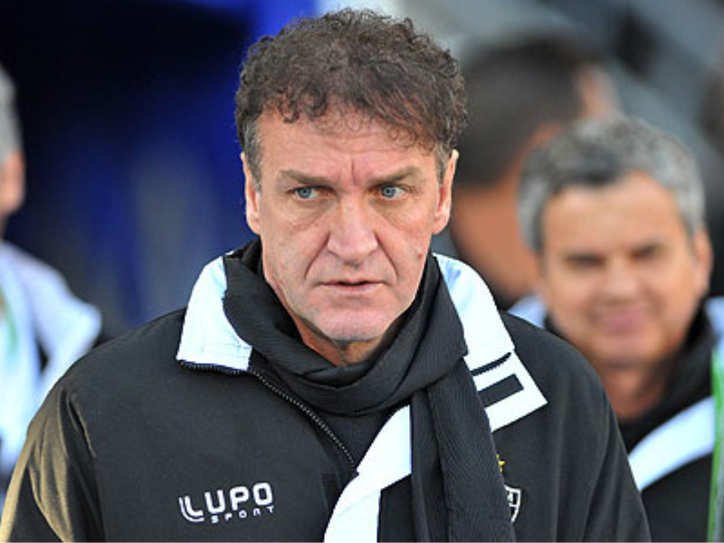 Cuca, ex-técnico do Atlético-MG, sentado em um vestiário com expressão de cansaço e desapontamento.