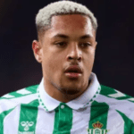 Smartphone exibindo manchete sobre Palmeiras e Vitor Roque em ambiente de escritório moderno.