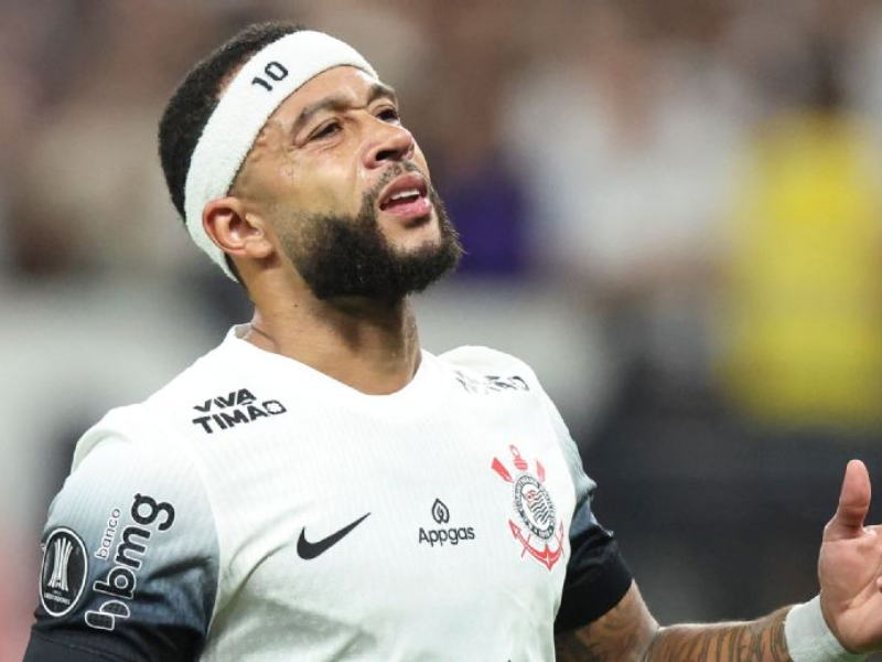 Memphis Depay sério em campo, vestindo uniforme do Atlético de Madrid.