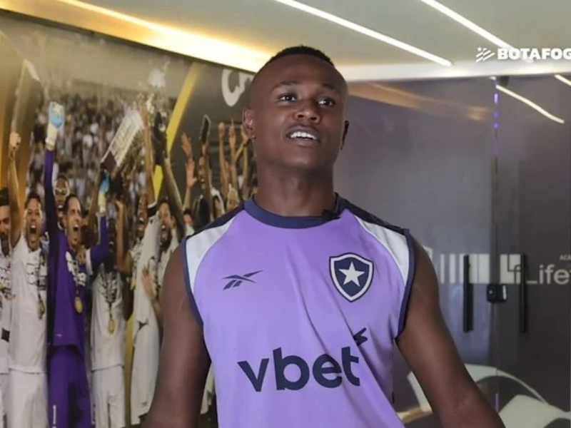 Nathan Fernandes, atacante do Botafogo, correndo no campo com uniforme do clube.