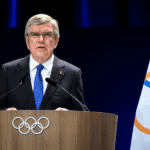 Retrato de Thomas Bach, ex-presidente do COI, em um momento de reflexão e satisfação.