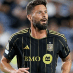 Retrato ultrarrealista de Olivier Giroud sorrindo, vestindo uniforme do LAFC, no gramado do BMO Stadium ao pôr do sol.