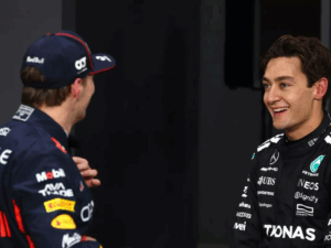 Riccardo Patrese, ex-piloto de F1, em seu escritório com luz natural, refletindo sobre estratégias de equipes e pilotos como Verstappen e Russell.