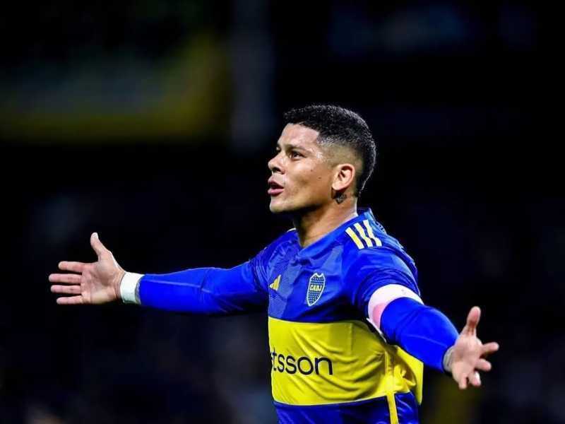 Imagem ultrarrealista de Marcos Rojo, jogador de futebol, com expressão frustrada em vestiário antigo, com um contrato amassado e uma bola de futebol.